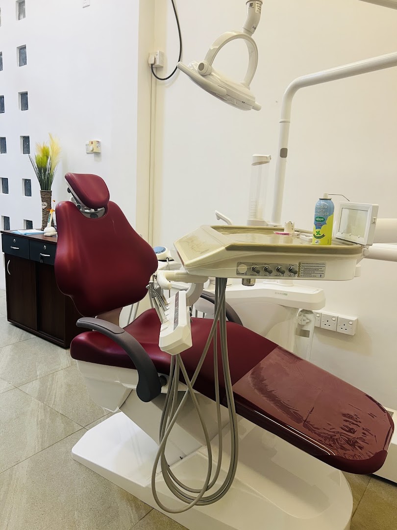 Burgundy dental chair and treatment light in a bright clinical room